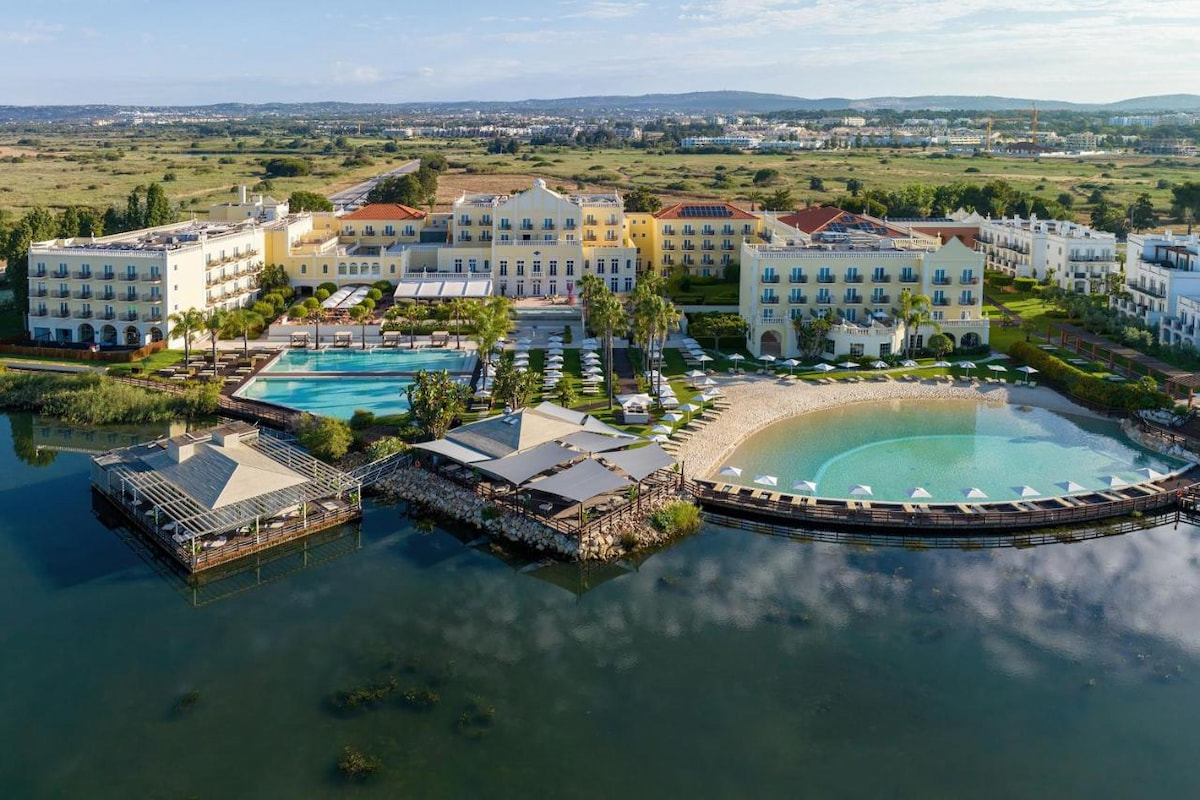 large luxury resort in Algarve sits on the riverfront with large oval shaped pool