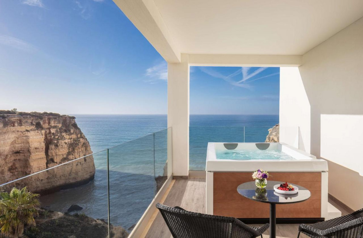 modern hotel balcony with jacuzzi overlooking the rugged Algarve town coastline
