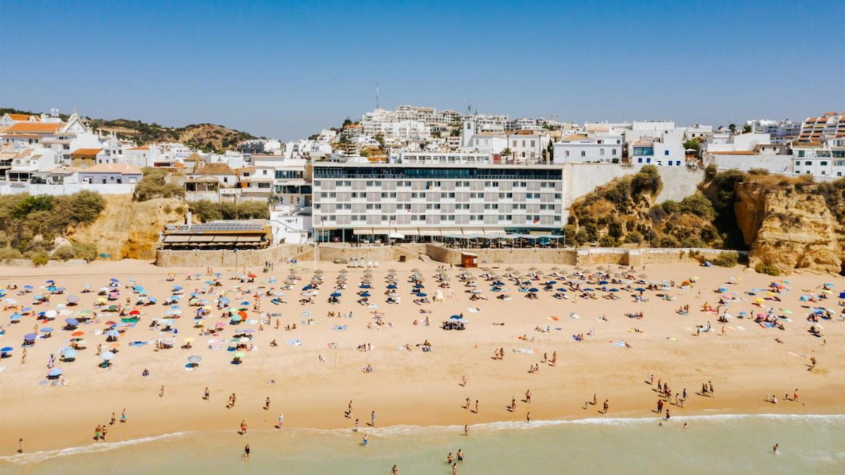 multi level beachfront resort in Algarve on a sandy beach with blue sky