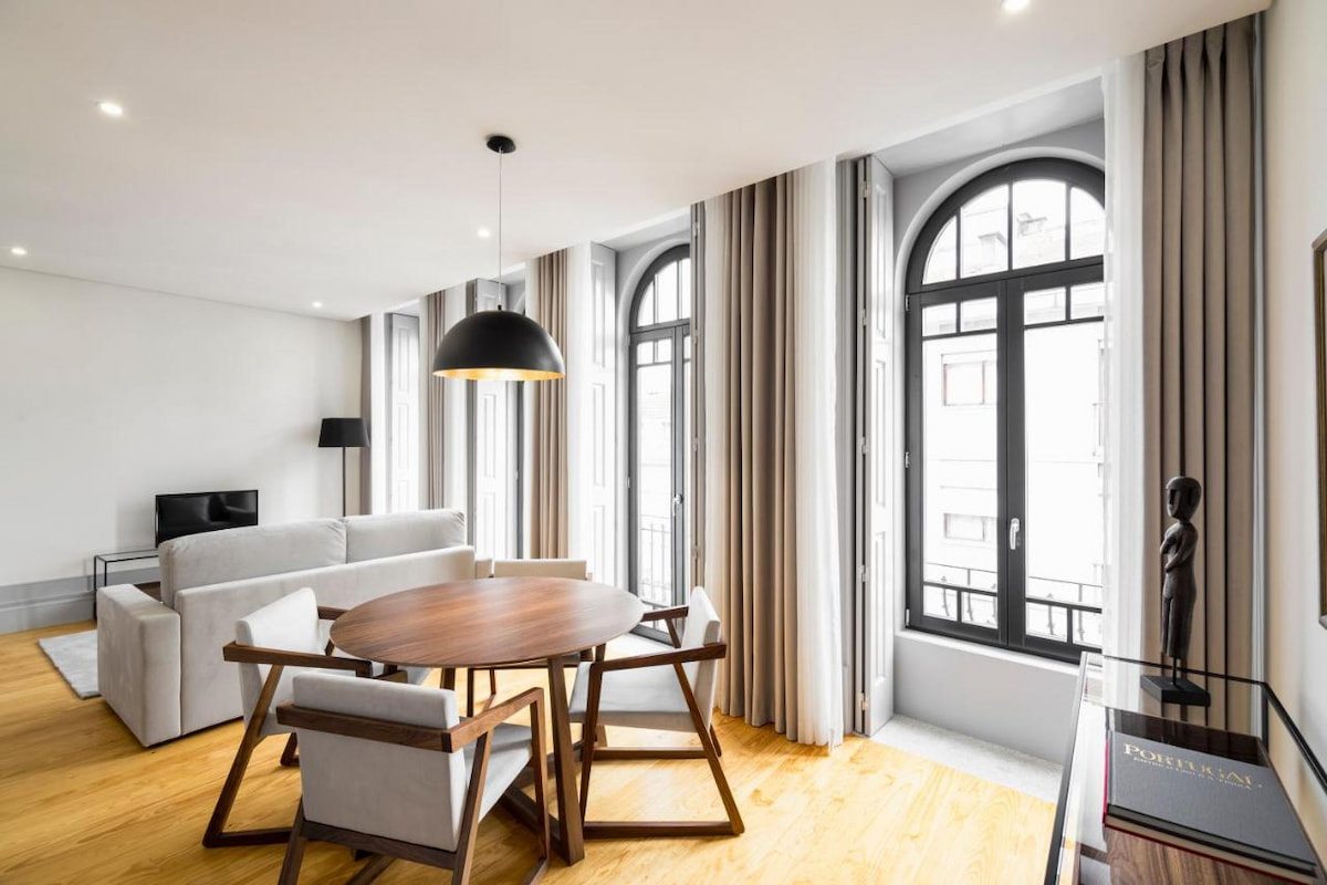 bright aparthotel in Porto with black framed arched windows and wood dining table in best location to stay in Porto