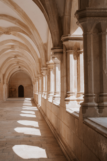 curved stone ceiling runs along a corridor at the Batalha Monastery, a great Lisbon day trip