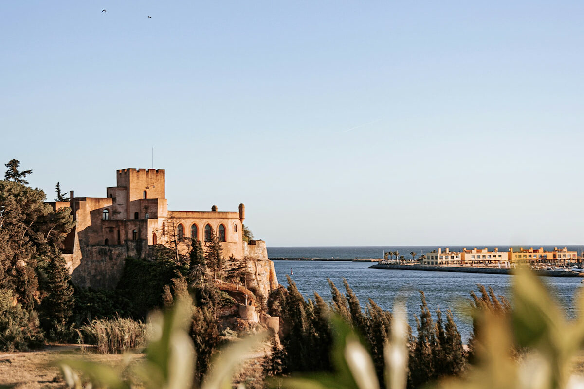 a moorish castle sits on the rugged coastline at golden hour in Ferragudo Algarve best area to stay