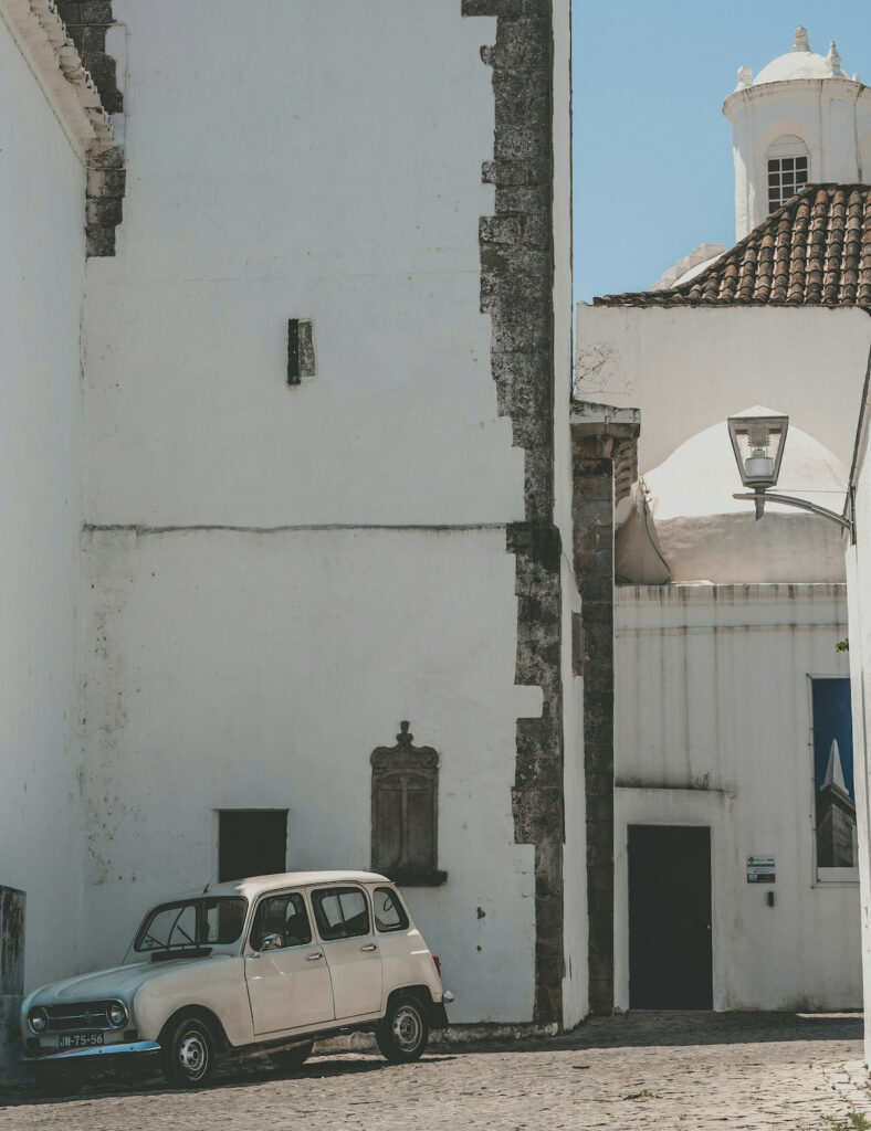 white vintage car parked by white buildings in Tavira Algarve Portugal