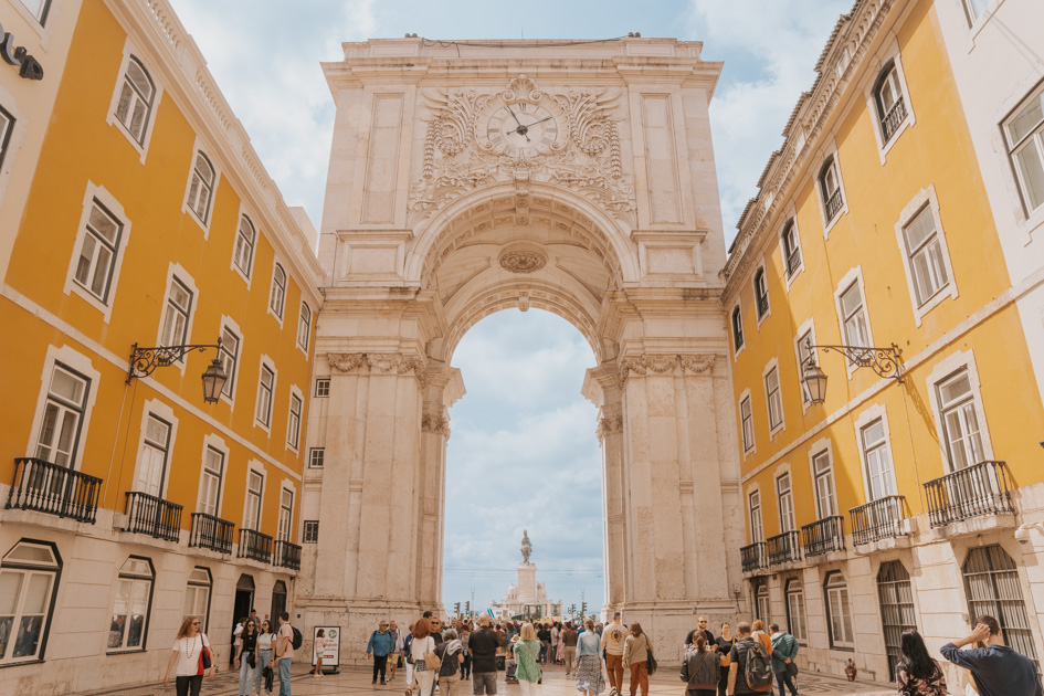 intricate and bold white stone arch leading out to placa do comercio in central Lisbon first time