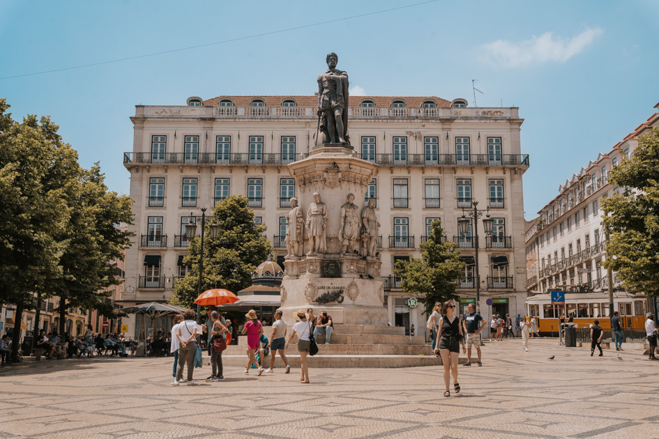bustling Praça Luís de Camões city square in Chiado Lisbon with monument on a blue sky day