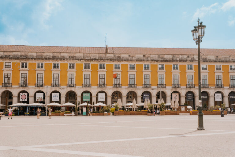 one day in Lisbon itinerary 24 hours in the placa do comercio with yellow buildings and blue sky