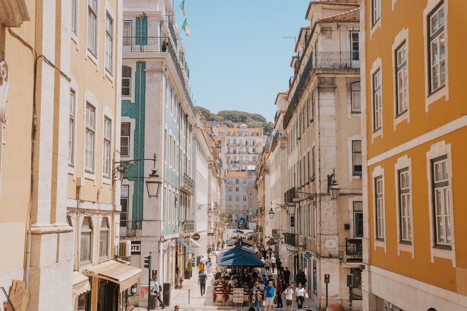 the bustling streets of Baixa stretch out between colourful buildings in downtown Lisbon 1 day itinerary