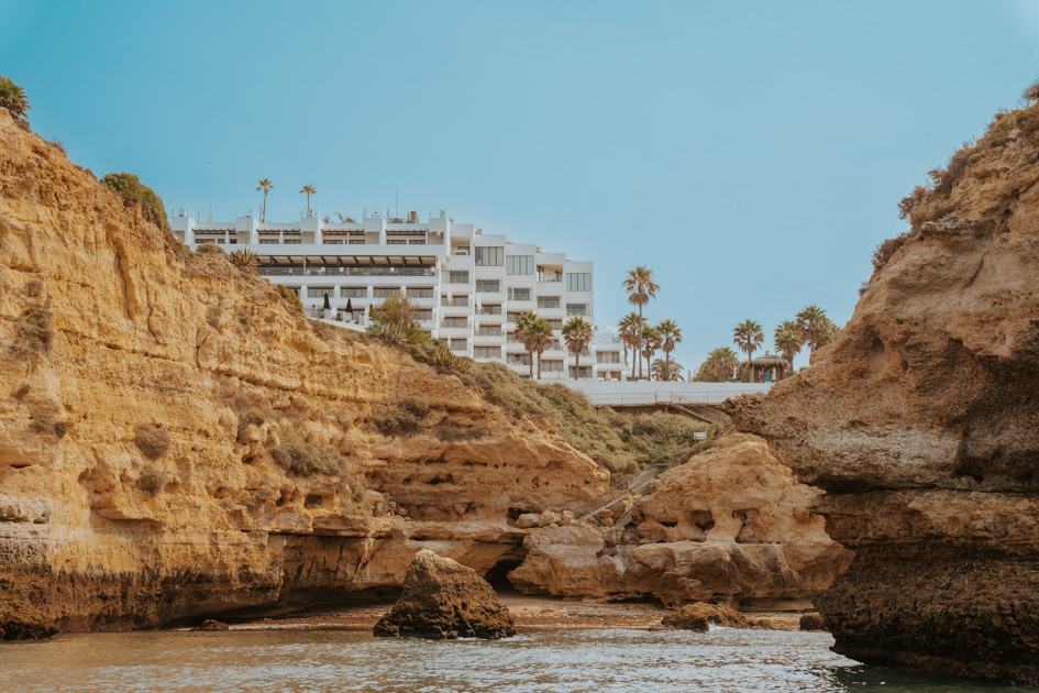 multi level beachfront resort in Algarve sits on the top of a rugged coastline on a clear sunny day