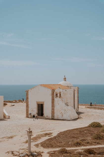 small white washed church sits in the plaza of Sagres Fortress which is where to stay in Algarve Portugal for surfing and young travellers