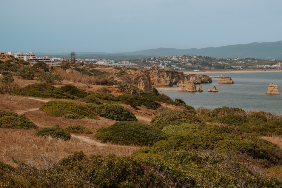 low bushlands cover the coastline looking towards one of the best locations to stay in Algarve Portugal Lagos