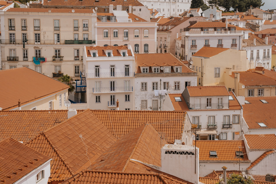 red tiled roofs top white buildings in an a chaotic layout in Lisbon neighbourhood Alfama perfect for couples for where to stay in Lisbon for first time visitors