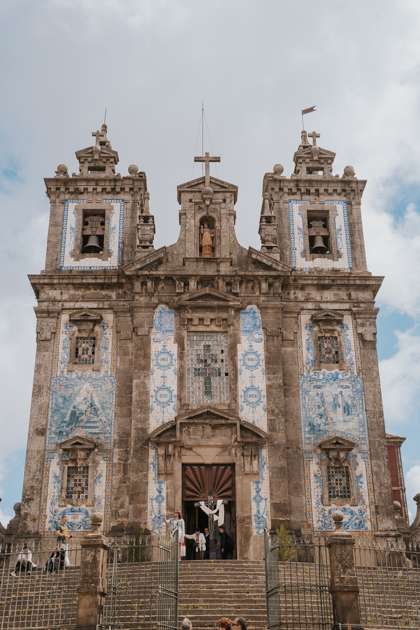 blue and white ceramic tiles adorn a historic church on a partly cloudy day in Porto's Bonfim neighbourhood