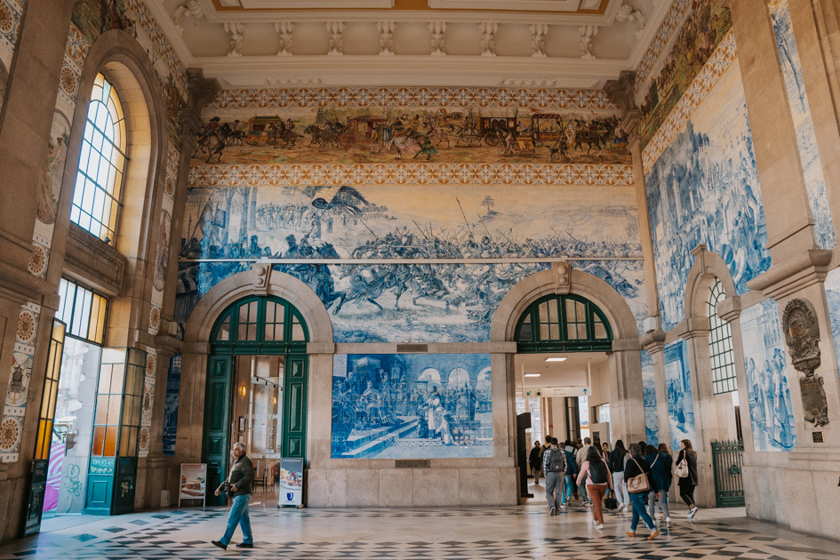Sao Bento Railway Station with its blue and white ceramic tiles adorning the wall and green arched doors in the historic neighbourhood in Porto